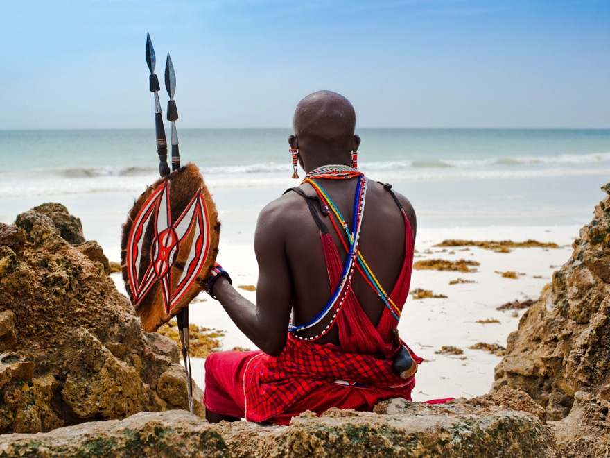 Maasai Man sitting by the Beach, in Traditional Attire