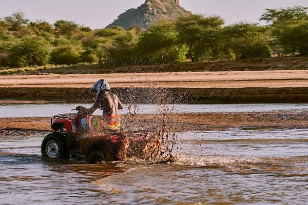 Man in Samburu attire riding a quad bike