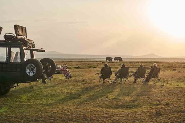 Tourists on safari, enjoy sundowners